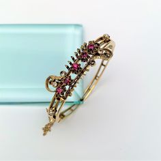 "This is a stunning Victorian era Etruscan revival hinged bangle bracelet. The piece is made of 14k gold and set with 2 round, single cut diamonds (2.15mm each), five remixed cut rubies (.65 ct.), and 2 cultured pearls. The bracelet has a locking closure with a safety chain. The piece is in excellent vintage condition with no visible flaws. The bracelet measures 2.1\" wide at the center, and weighs 21.6 grams. There is an appraisal included. If you have any questions or would like to see additio Antique Yellow Gold Hallmarked Bangle, Antique Hallmarked Yellow Gold Bangle, Vintage 14k Gold Hallmarked Bangle, Antique 14k Gold Round Bangle, Antique Round 14k Gold Bangle, Vintage 14k Gold Bangle, Antique 14k Gold Bangle For Anniversary, Antique Hallmarked Cuff Bracelet For Wedding, Antique Yellow Gold Hallmarked Cuff Bracelet