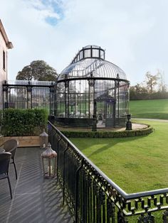 a gazebo sitting on top of a lush green field next to a tall building