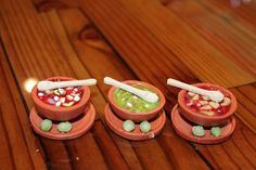 three small bowls filled with candy and marshmallows