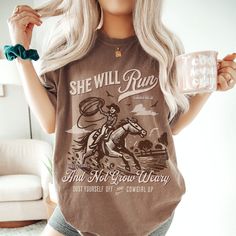 ✨"She Will Run and Not Grow Weary"✨ Unleash your inner cowgirl with our "She Will Run and Not Grow Weary" t-shirt, inspired by Isaiah 40:31. This bold design features a dynamic cowgirl on horseback, symbolizing resilience and faith. Perfect for anyone who loves western themes and inspirational messages, this tee is a stylish reminder to keep your faith strong and your spirit unbroken. Tags: #CowgirlFaith #WesternApparel #InspirationalTee #BibleVerseShirt #ChristianClothing #Isaiah4031 #FaithFashion #CowgirlUp #ResilientSpirit #ReligiousTshirt #CowgirlLife #ChristianGifts #MotivationalWear Comfort Colors ＦＡＢＲＩＣＡＴＩＯＮ ＆ ＰＲＩＮＴＩＮＧ ✿ Please note: The colors of the text, design, and/or shirt may vary slightly from the photo shown, due to lighting, printing, or computer and phone screens. ✿ 100% r Cheap Graphic Print Tops For Western-themed Events, Casual Shirt With Digital Print, Western Cricut Tshirts, Cute Cricut Shirts Western, Western Shirts Vinyl Bohemian, Horse Cricut Shirts, Western Women Outfits, Country Boho Outfit, Western Tee Shirts