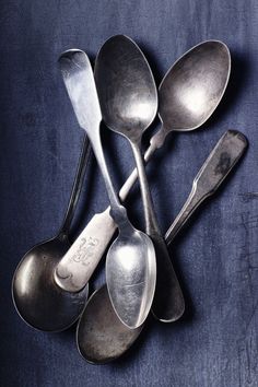 five old spoons on a blue cloth