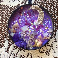 a glass pendant with sea shells and stars on it