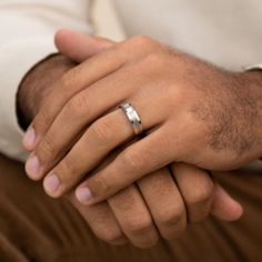 a close up of a person wearing a ring on their finger and holding the other hand