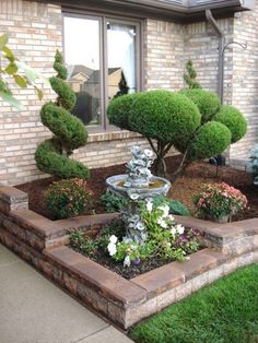 a small garden in front of a brick house