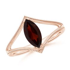 a yellow gold ring with a large red stone in the center and an intricate band around it