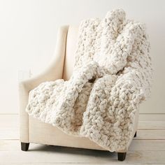 a white chair with a blanket on it