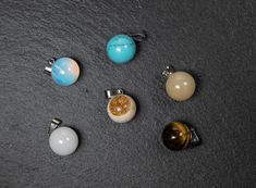 Round gemstone Ball Pendant, Variety of Stone Types to Choose from - some natural (N), some natural colored (C), some synthetic ( S). Please note stone patterns and undertones may vary, you will receive a random pendant of selected material. Stone Size: approx 13-14mm in diameter Finding attachment Hole Size: about 2-3 mm Price per 1 pendant Thank you ;) Natural Stone Pendant Crystals For Jewelry Making, Gemstone Round Pendant Necklace For Meditation, Agate Gemstone Beads Pendant, Round Agate Natural Stones For Beads And Cabochons, Round Agate Beads And Cabochons With Natural Stones, Healing Round Agate Gemstones, Natural Round Agate Stones, Natural Agate Stones Round Beads, Gift Multi-stone Round Beads Gemstones