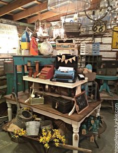 an old fashioned typewriter sitting on top of a table in a room filled with antiques