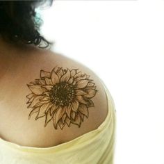 a woman with a sunflower tattoo on her shoulder