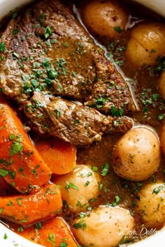 a bowl filled with meat and potatoes on top of a table