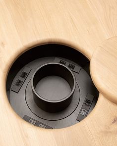 a wooden toilet seat with an electronic device in the center and buttons on the lid