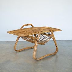 a wicker chair with handle rests on concrete floor