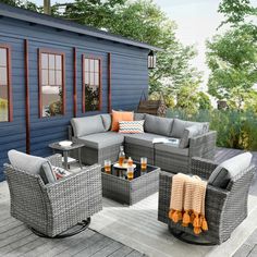 an outdoor living room with grey wicker furniture