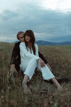 two people are sitting in the tall grass