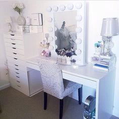 a white desk with a mirror, chair and lamp on it's side in a room