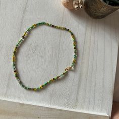 🐢 A handmade necklace with shades of green, yellow, brown and clear beads, finished with gold plated clasp. Designed as a 16 inch loose choker style necklace with elasticated thread :) xx Green Tiny Beads Choker, Green Choker With Tiny Round Beads, Adjustable Green Choker With Tiny Beads, Green Choker With Colorful Beads For The Beach, Green Colorful Beads Choker For Beach, Adjustable Yellow Choker With Tiny Beads, Green Beach Choker With Colorful Beads, Adjustable Yellow Round Beads Choker, Beach Choker With Colorful Green Beads