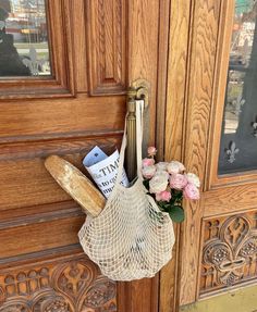 a door handle with some flowers in it and a bag hanging on the front door