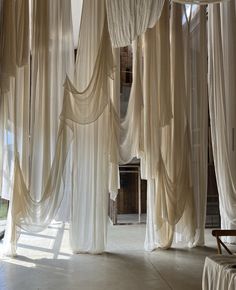 an open room with white drapes hanging from the ceiling