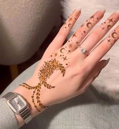 a woman's hand with hennap and stars on her left arm, showing the