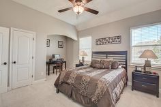 a bedroom with a bed, dresser and ceiling fan