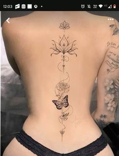 the back of a woman's body with tattoos and flowers on her lower back