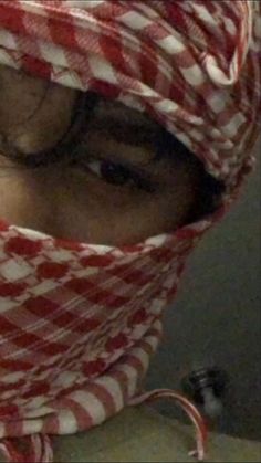 a woman wearing a red and white scarf covering her face