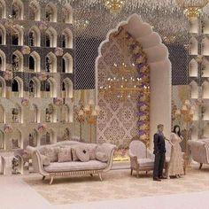 a man and woman standing in front of an elaborately decorated living room with chandeliers