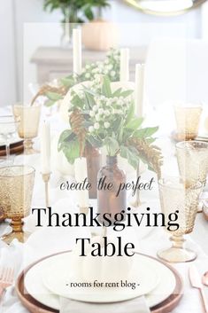 a thanksgiving table setting with candles, flowers and greenery in a vase on top