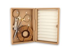 an open box with scissors, combs and other items in it on a white background