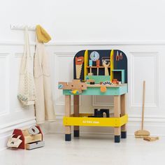 a child's play table with toys on it in front of a white wall