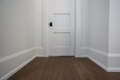 an empty room with white walls and wood flooring is pictured in this image from the front door