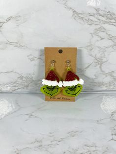 the grin face earrings are decorated with red glitter and white santa claus's hat