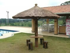 a gazebo next to a swimming pool in the middle of a yard with benches and tables around it