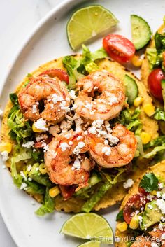 two shrimp tacos with avocado and tomatoes