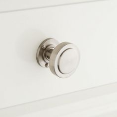 a close up of a knob on a white cabinet