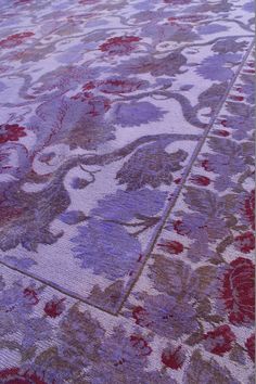 an area rug with red and purple flowers on it