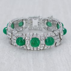 A fantastic Art Deco style bracelet featuring round brilliant cut diamonds and emerald cabs. This bracelet is finely crafted in 18k white gold, featuring a diamond total carat weight of 15.00 carats. The 9 emeralds measure to 36.00 carats. Details- 18k White Gold Cut: Round Brilliant Cut Diamond total carat weight: 15.00cts Additional Gemstone Details: Featuring 9 Emerald Cabs Total Cab carat weight: 36.00cts This stunning Art Deco Diamond and Emerald Cab Bracelet is only available at Burdeen's Black Diamond Bands, Art Deco Bracelet, Emerald Bracelet, Jewelry Post, Gold Art Deco, Art Deco Diamond, Fine Jewels, Fantastic Art, Gold Art