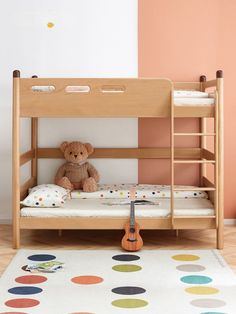 a teddy bear sitting on top of a bunk bed next to a rug with polka dots