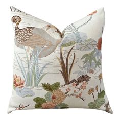 a white pillow with a bird and flowers on the front, along with water lilies