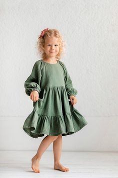 This dreamy dress, the perfect choice for your little one. Crafted from soft muslin fabric with a hint of shimmer, it exudes elegance. The puffed long sleeves add a touch of whimsy, perfect for twirling in style. 🌟 Whether it's a festive family gathering, a flower girl moment, or a birthday celebration, this dress will make your princess shine. DETAILS: * Made of 100% OEKO-TEX certified double gauze fabric * Back handy snaps closure * Long, puffed sleeves with elastic hem * Gathered skirt * Ava Cotton Billowy Long Sleeve Dress, Billowy Cotton Dress With Balloon Sleeves, Billowy Cotton Long Sleeve Dresses, Billowy Long Sleeve Cotton Dress, Cotton Dresses With Balloon Sleeves, Cotton Dresses With Gathered Balloon Sleeves, Solid Dress With Gathered Balloon Sleeves, Cotton Puff Sleeve Dress With Gathered Sleeves, Flowy Lantern Sleeve Dress With Ruffles