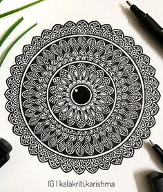 an intricate design is shown on a piece of paper next to some pens and markers