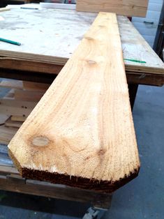 a bench made out of wood sitting on top of pallets in a warehouse or workshop