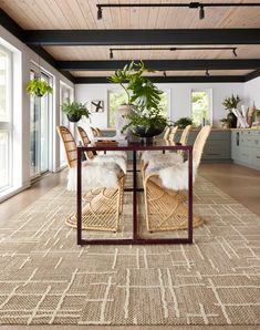 a dining room table with chairs and plants on top of it in the middle of an open floor plan