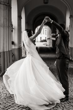 a bride and groom dancing in an archway