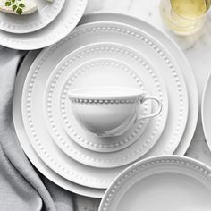 white plates and silverware are laid out on a marble table