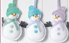 three snowmen hanging from hooks on a wall