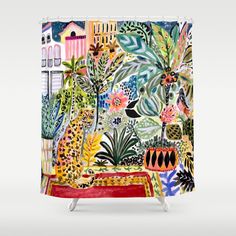 a colorful shower curtain with an image of plants and buildings in the background, on a white