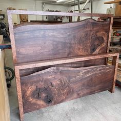 a large wooden bed frame sitting in a room next to other woodworking tools and materials