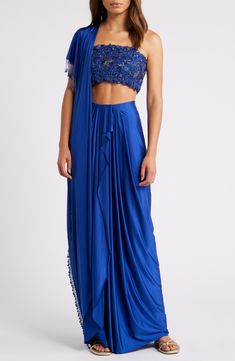 Make an elegant appearance in a graceful set including a hand-embroidered crop top, pleated sari-like skirt and a dupatta trimmed in beaded pearl fringe. 7" (top), 42 1/2" (bottom) (size Medium) Top has side-zip closure; square neck; adjustable straps Skirt has side-zip closure Lined 100% polyester Spot clean Made in India Asian & Pacific Islander Owned/Founded Strap Skirt, Embroidered Crop Tops, Lehenga Choli, Western Outfits, Square Neck, Indian Outfits, Wedding Outfit, Lehenga, Hand Embroidered