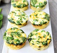 small muffins with spinach and cheese on a white plate next to eggs